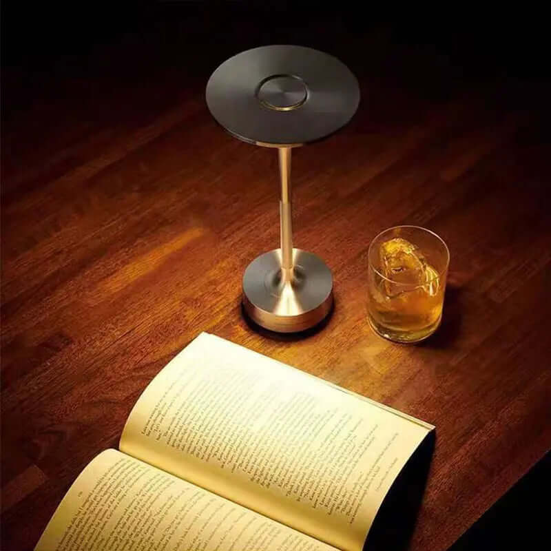 Small Table Lamps | indoor/outdoor. Silver lamp on wood table with a book and a drink.  Malonesspecialtystore.com 